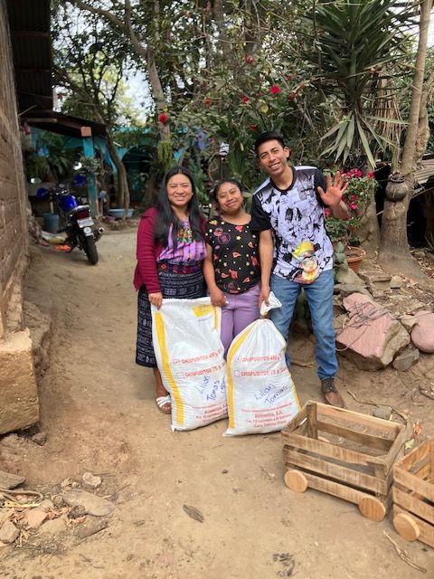 Community members with bags of food supplies for classrooms